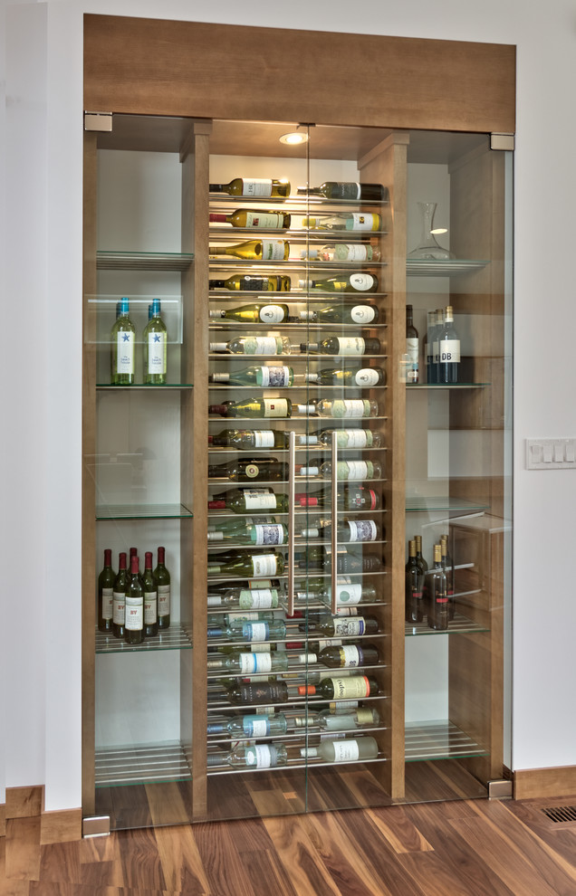 Design ideas for a small contemporary wine cellar in Other with medium hardwood flooring and storage racks.