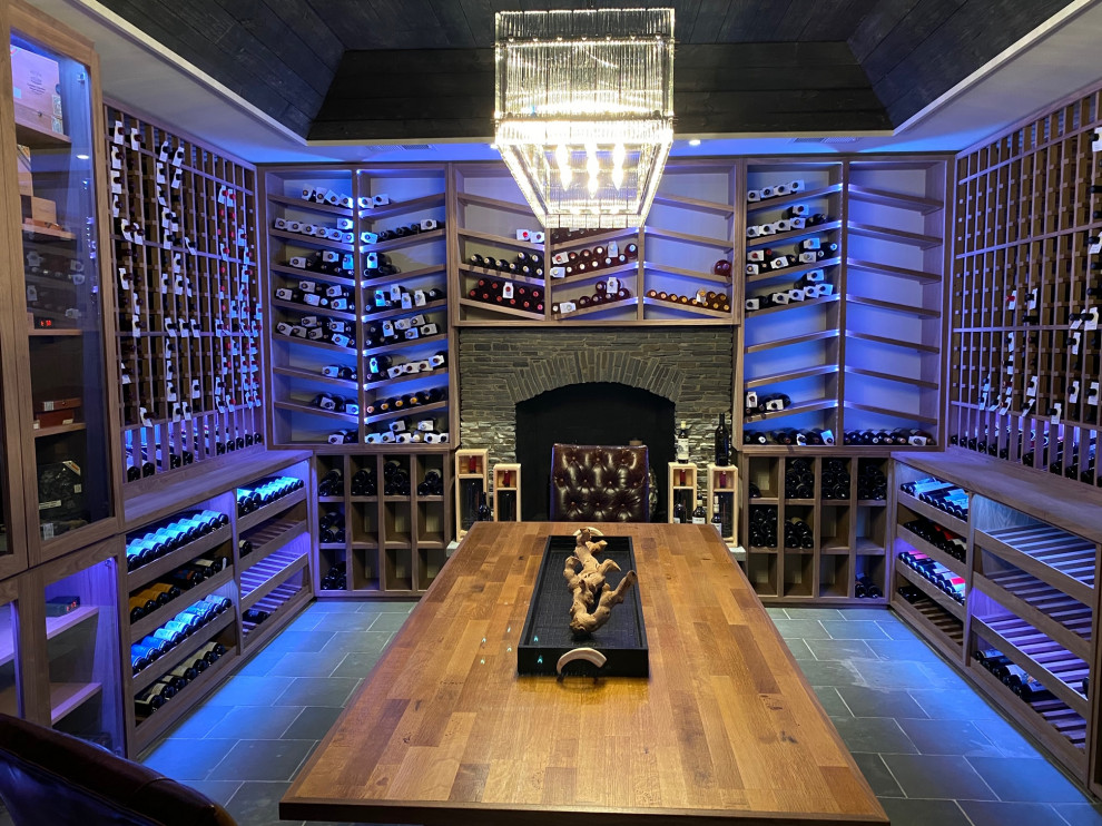 This is an example of a large rustic wine cellar in Chicago with slate flooring, storage racks and grey floors.
