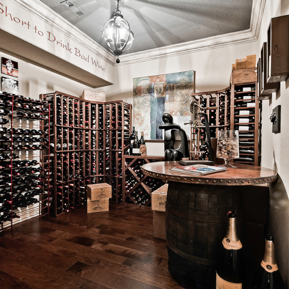 Photo of a medium sized bohemian wine cellar in Other with dark hardwood flooring, storage racks and brown floors.