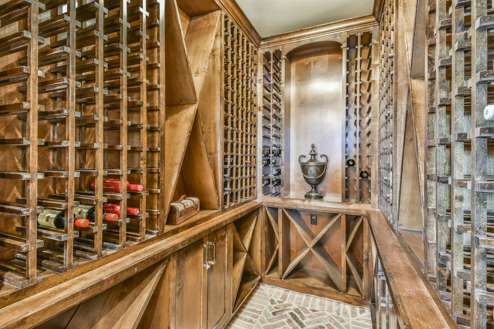 Transitional wine cellar in Houston with brick floors, storage racks and brown floor.