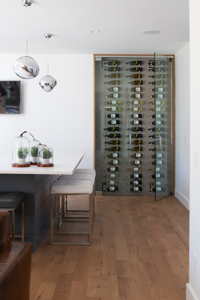 Cette image montre une cave à vin design avec des casiers et parquet clair.