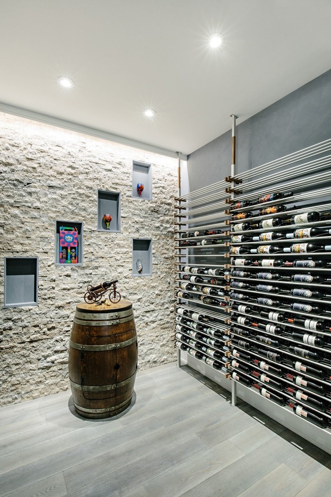 Foto på en funkis vinkällare, med vindisplay och grått golv