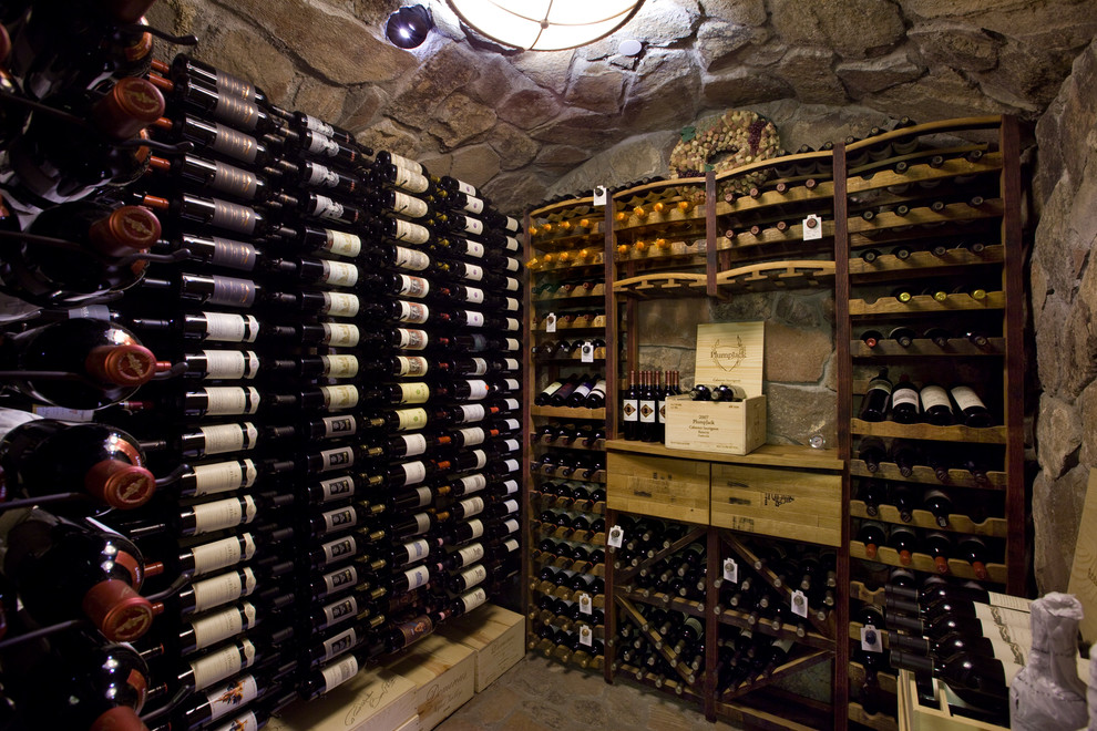 Cette photo montre une grande cave à vin montagne avec sol en béton ciré, des casiers et un sol marron.