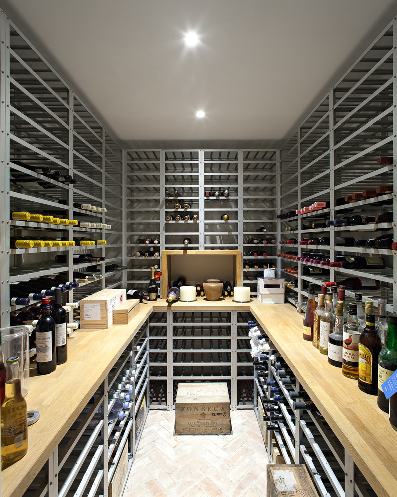Inspiration for a traditional wine cellar in London with brick flooring and storage racks.