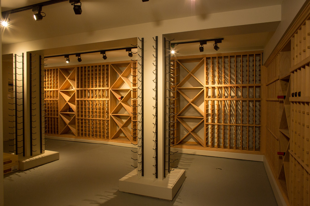 Aménagement d'une grande cave à vin classique avec sol en béton ciré et des casiers.