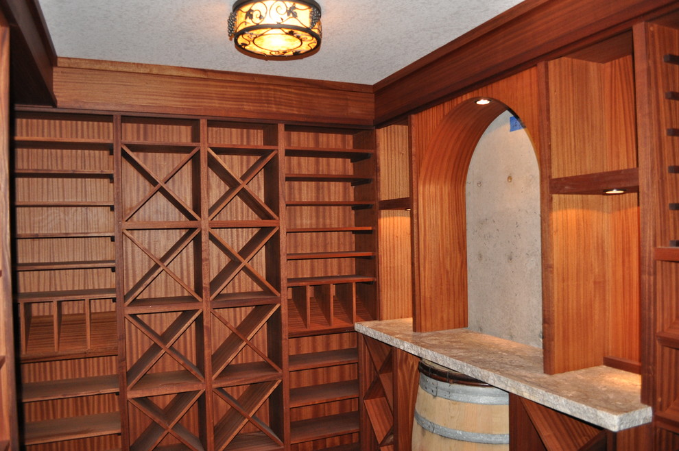 Wine cellar - mid-sized mediterranean concrete floor and brown floor wine cellar idea in Portland with diamond bins
