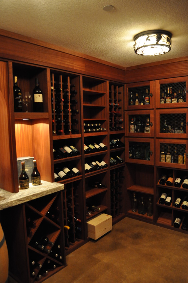 Wine cellar - mid-sized mediterranean concrete floor and brown floor wine cellar idea in Portland with diamond bins