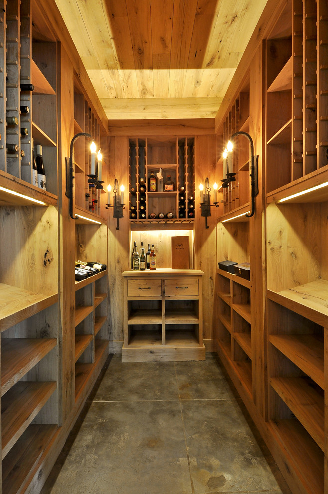 Cette photo montre une cave à vin chic avec sol en béton ciré.