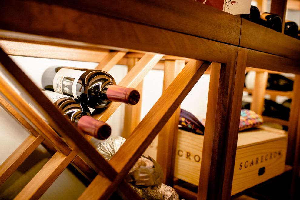 Bild på en mellanstor vintage vinkällare, med mellanmörkt trägolv, vinhyllor och brunt golv