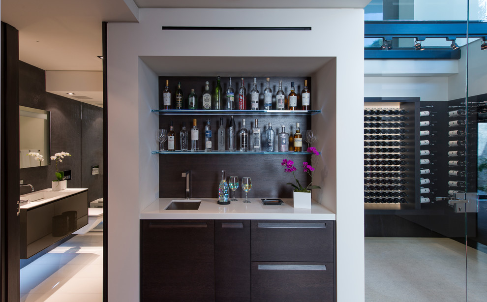 This is an example of an expansive modern wine cellar in Los Angeles with storage racks, white floors and feature lighting.