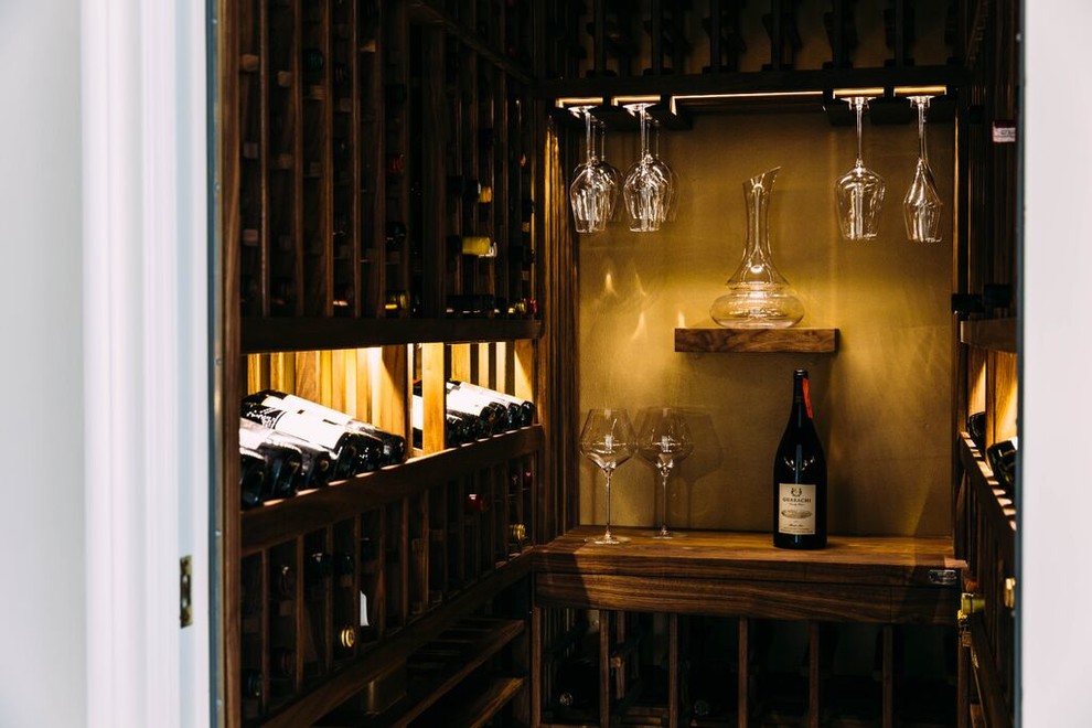 Cette photo montre une petite cave à vin chic avec un sol en marbre et des casiers.