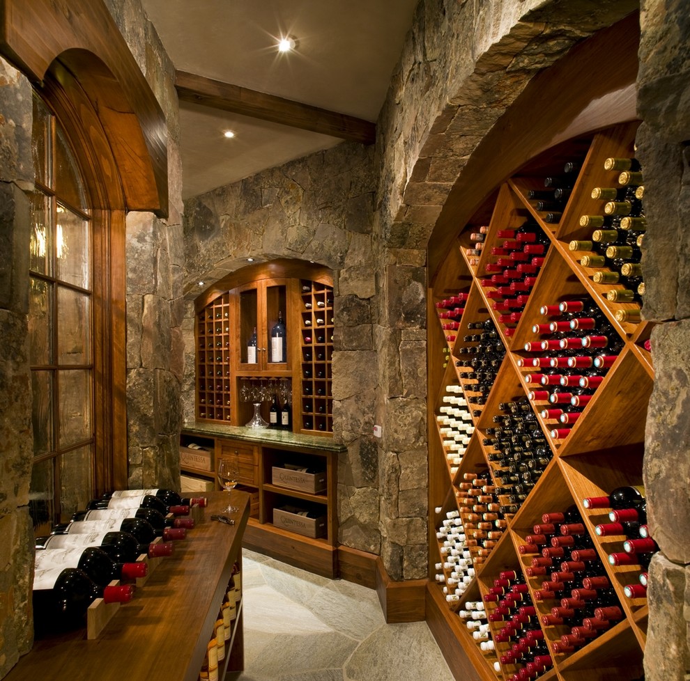 Aménagement d'une grande cave à vin montagne avec des casiers losange.