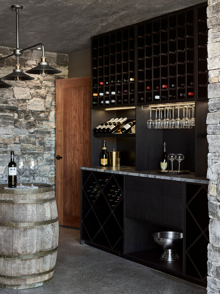 Foto på en mellanstor funkis vinkällare, med betonggolv, vindisplay och grått golv