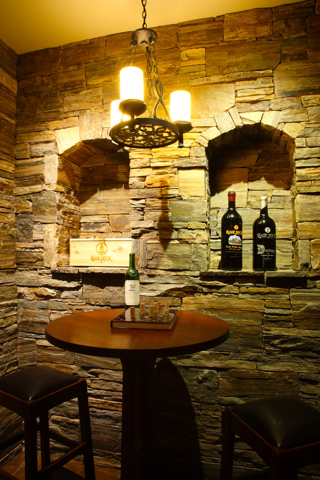 Foto på en mellanstor amerikansk vinkällare, med vinhyllor och betonggolv