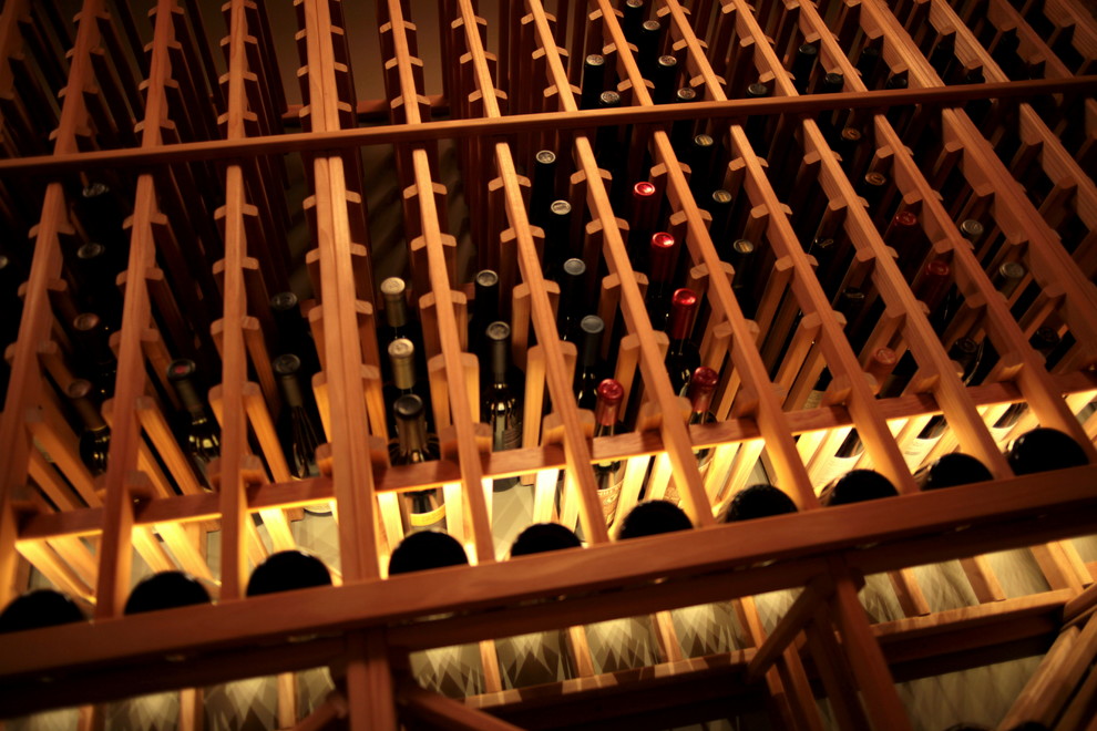 Bild på en mellanstor vintage vinkällare, med mellanmörkt trägolv och vinhyllor