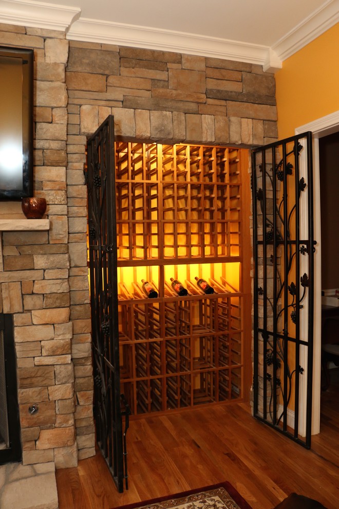 Exemple d'une petite cave à vin chic avec un sol en bois brun et des casiers.