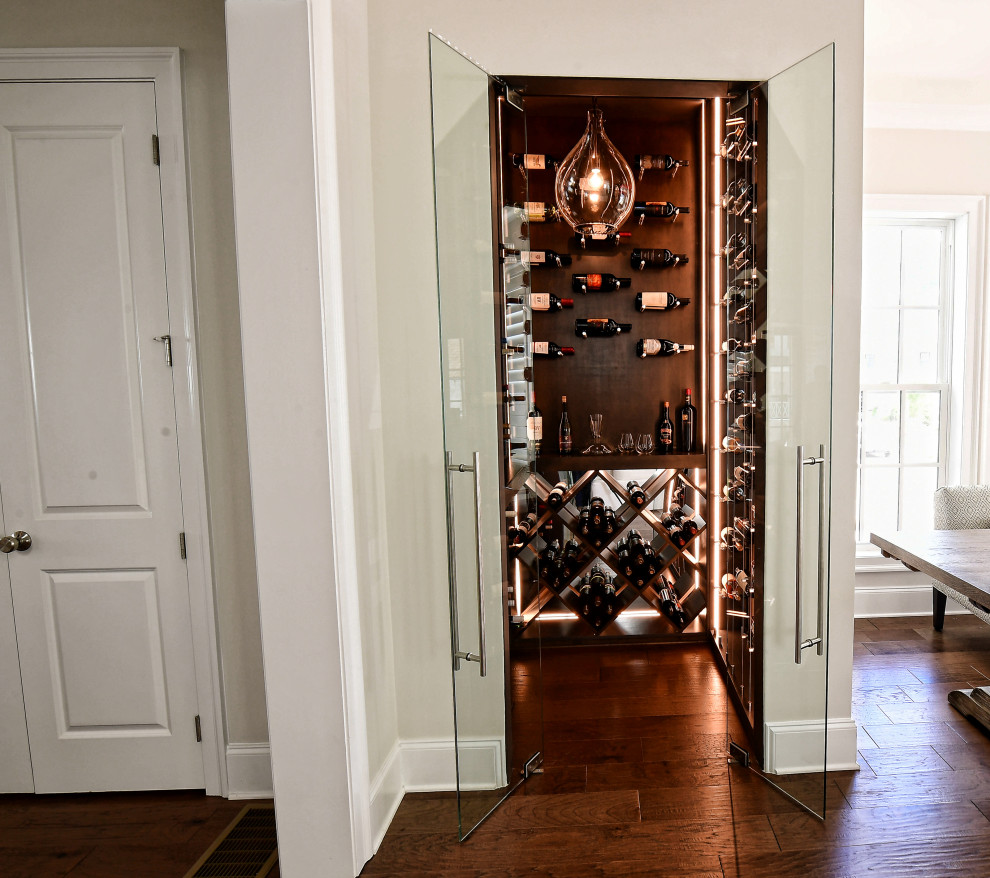 Small traditional wine cellar in Atlanta with dark hardwood flooring, cube storage and brown floors.