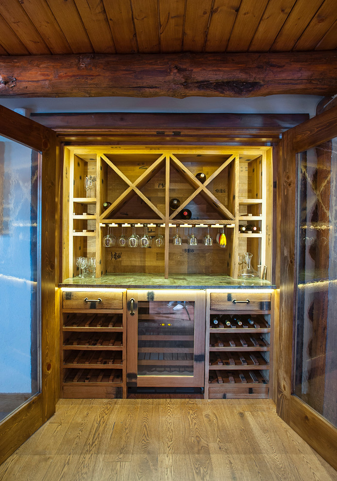 Exempel på en liten rustik vinkällare, med mellanmörkt trägolv och vinställ med diagonal vinförvaring