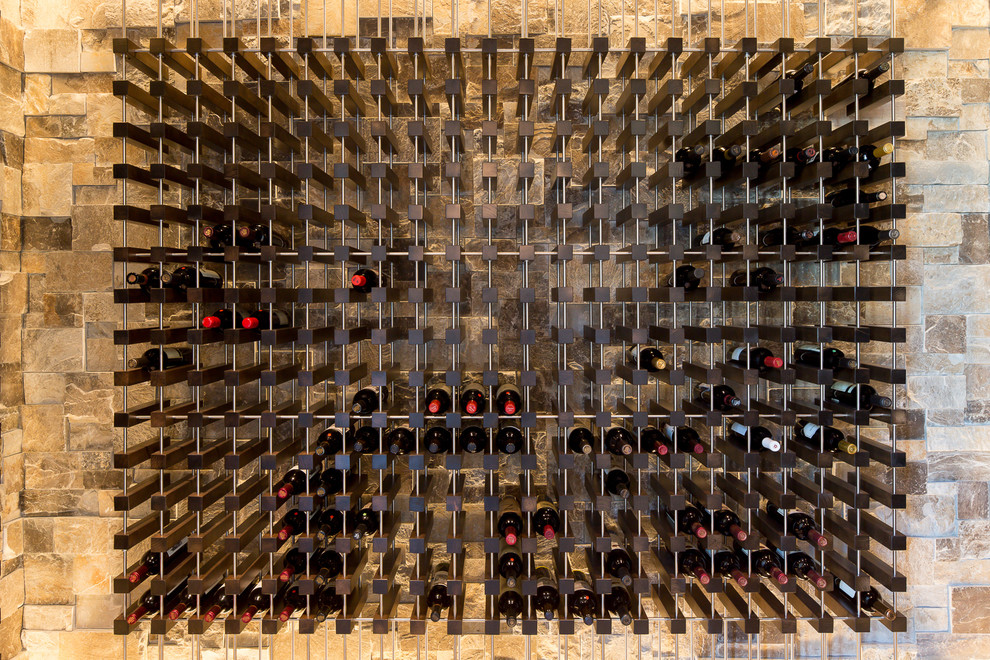 Cette image montre une cave à vin méditerranéenne de taille moyenne avec un sol en carrelage de céramique, des casiers et un sol beige.
