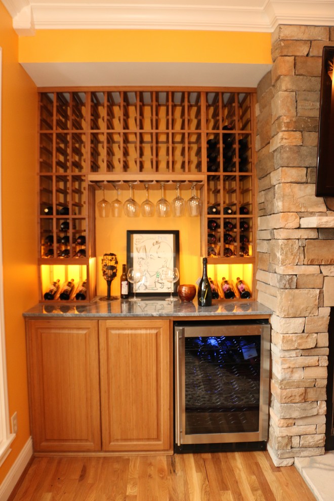 Idées déco pour une petite cave à vin classique avec parquet clair et des casiers.