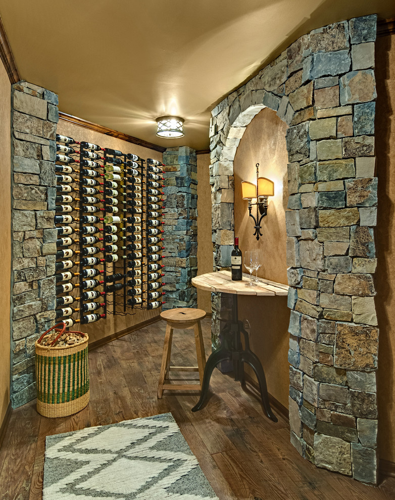 Cette photo montre une cave à vin nature de taille moyenne avec un sol en bois brun et des casiers.