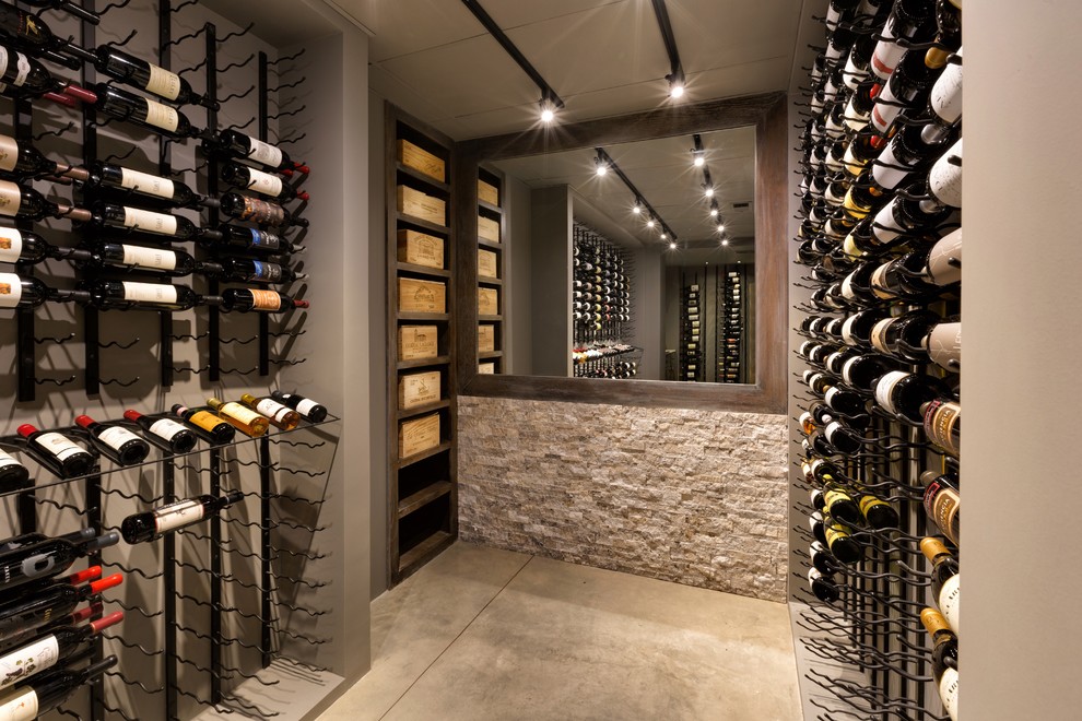 Cette image montre une cave à vin traditionnelle de taille moyenne avec sol en béton ciré et des casiers.