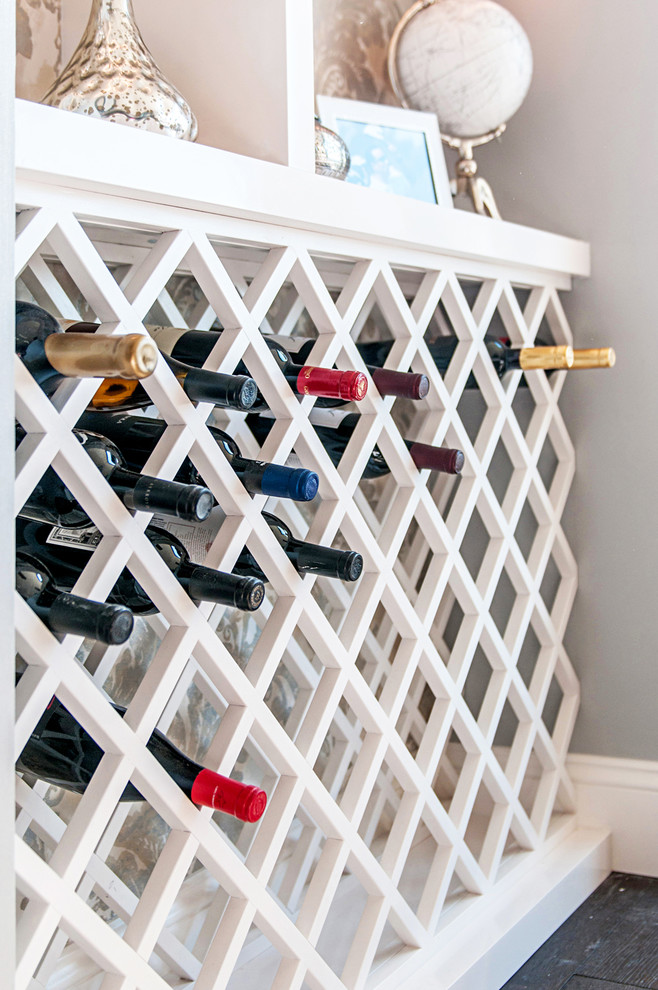 This is an example of a small modern wine cellar in San Diego with dark hardwood flooring and cube storage.
