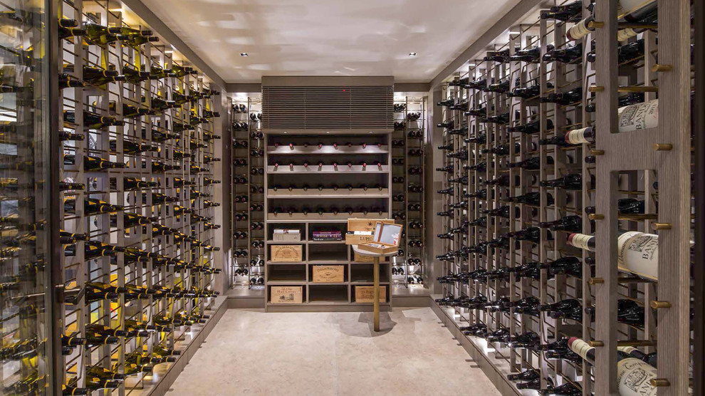 This is an example of a medium sized traditional wine cellar in London with storage racks and beige floors.