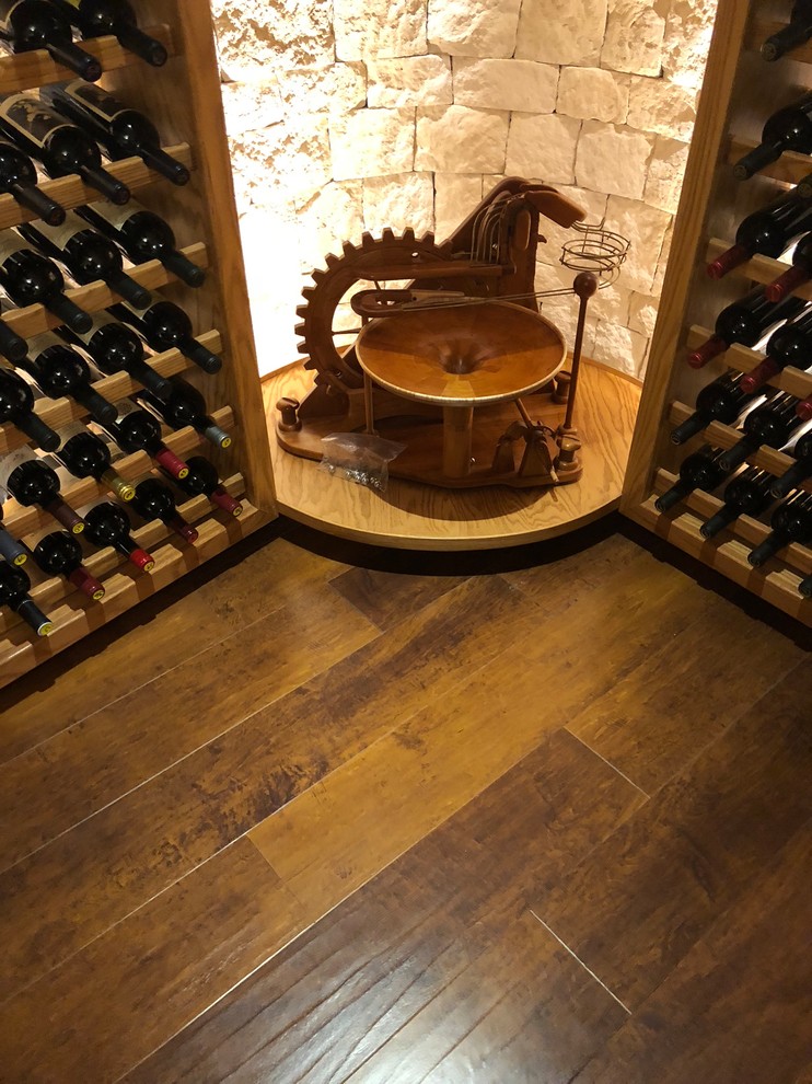 Cette image montre une grande cave à vin traditionnelle avec un sol en vinyl et un sol marron.