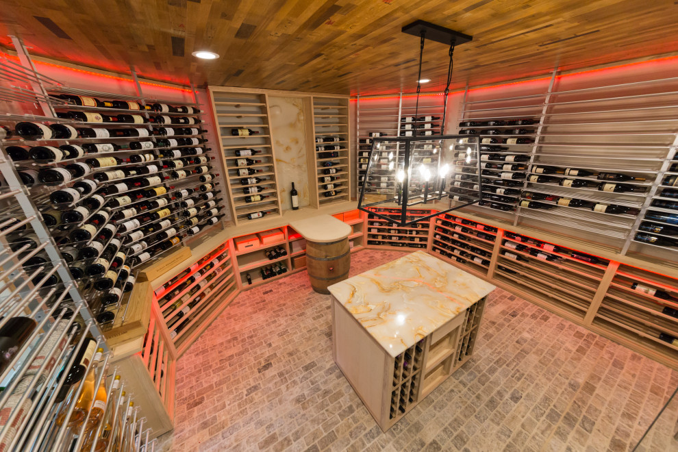 Cette photo montre une grande cave à vin chic avec un sol en brique, un présentoir et un sol gris.
