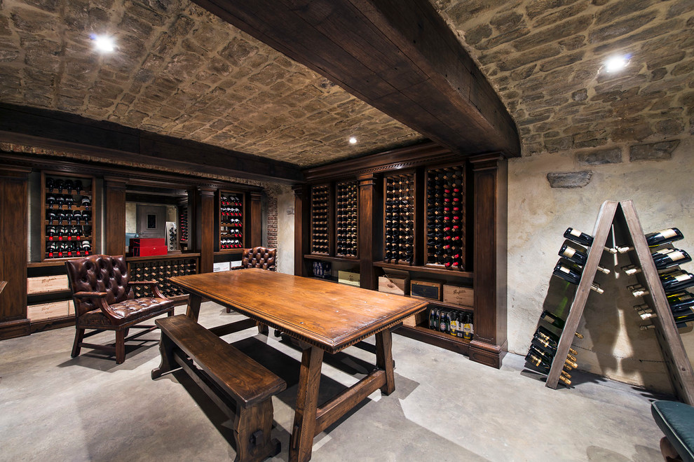 Idée de décoration pour une cave à vin tradition avec sol en béton ciré et des casiers.