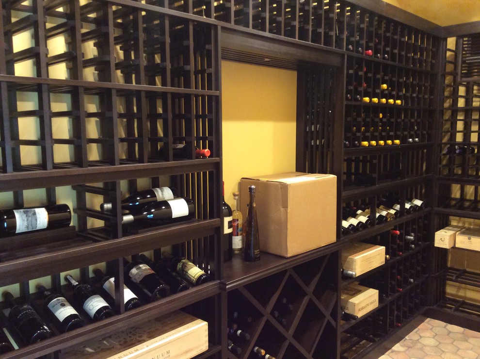 Medium sized traditional wine cellar in Los Angeles with terracotta flooring and display racks.