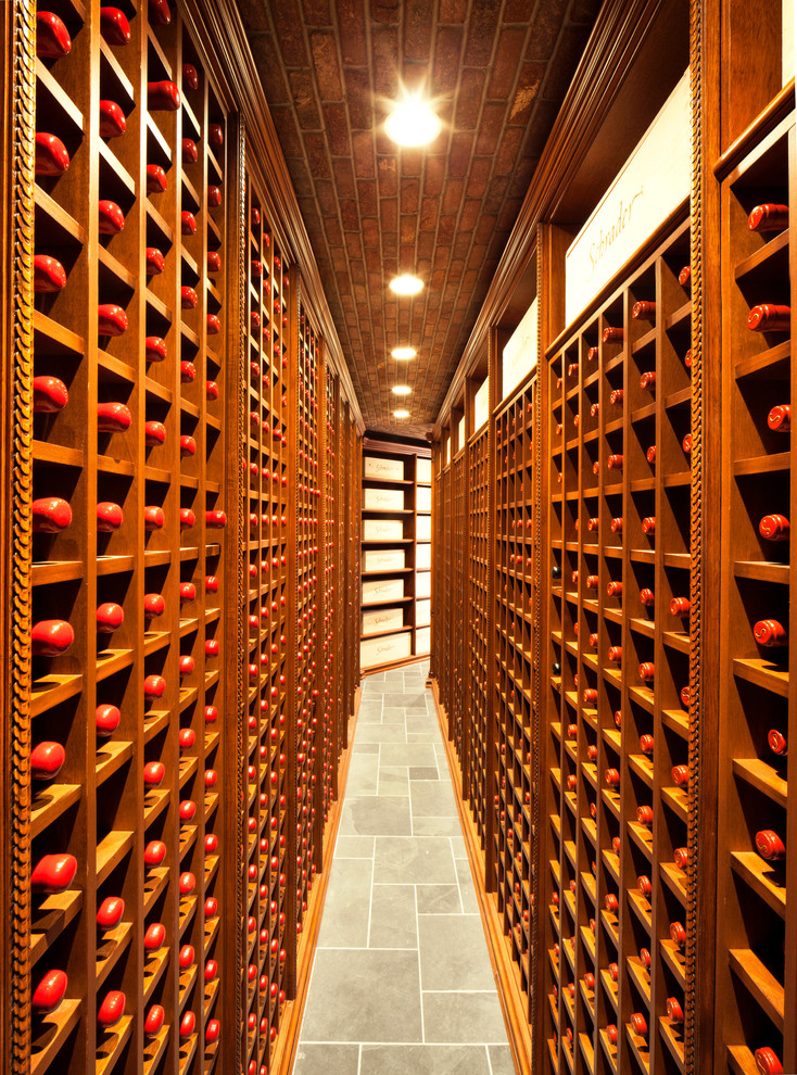 Photo of an expansive classic wine cellar in New York with display racks and grey floors.