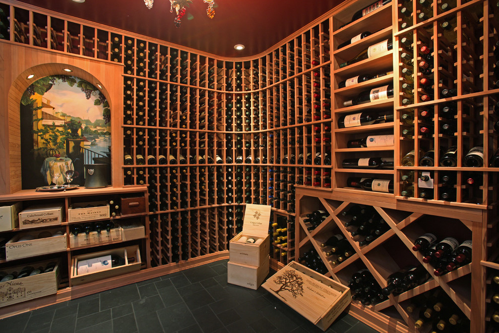 Cette photo montre une grande cave à vin chic avec un sol en ardoise, des casiers et un sol noir.