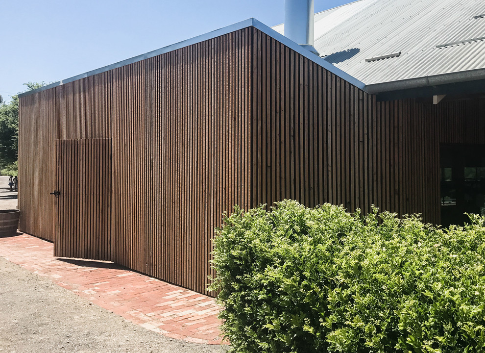 Idée de décoration pour une petite cave à vin design avec tomettes au sol et un sol marron.