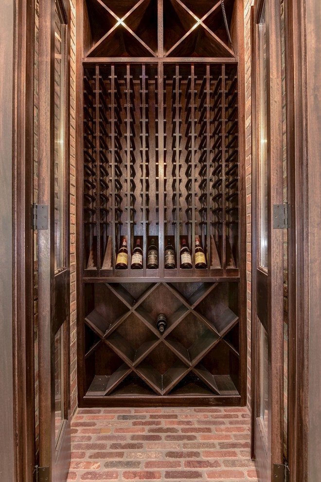 Foto på en stor funkis vinkällare, med tegelgolv och vinställ med diagonal vinförvaring