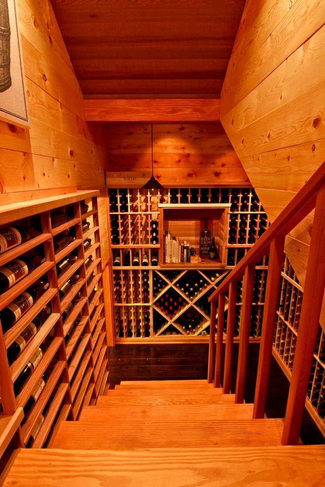 Idée de décoration pour une cave à vin chalet de taille moyenne avec parquet foncé et des casiers.