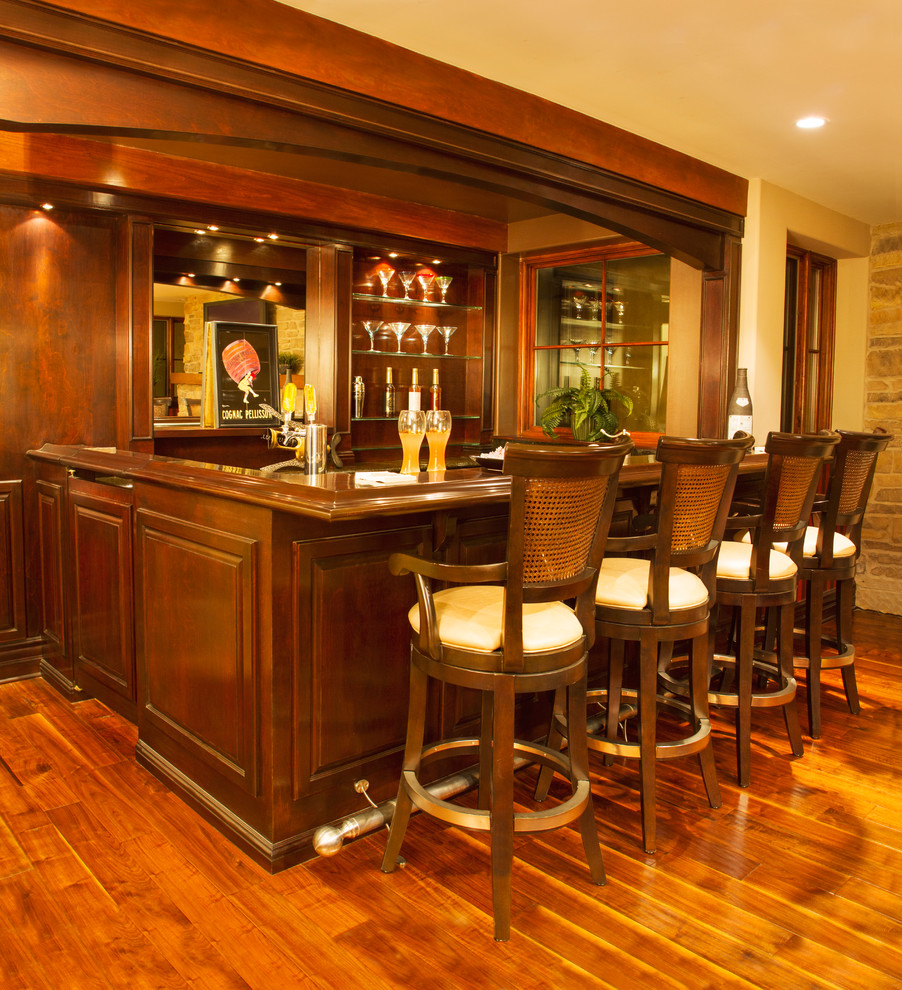 Inspiration for a mediterranean home bar in Los Angeles with brown floors and medium hardwood flooring.