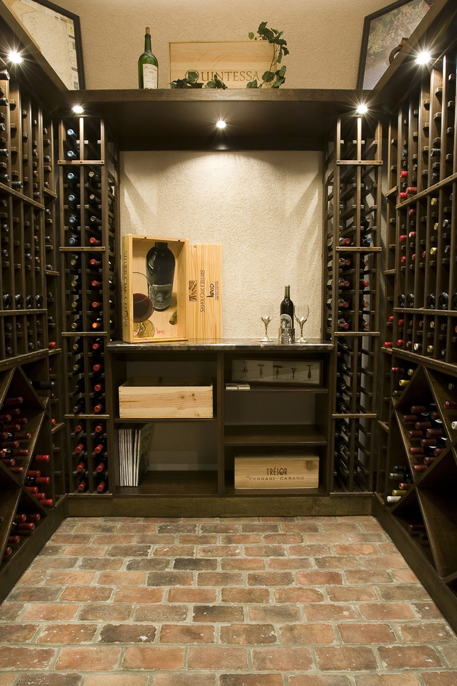 Photo of a mediterranean wine cellar in Other with brick flooring, storage racks and red floors.