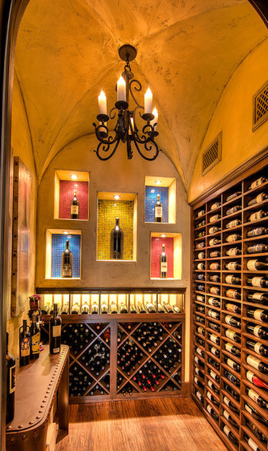 Large tuscan medium tone wood floor and brown floor wine cellar photo in Dallas with display racks