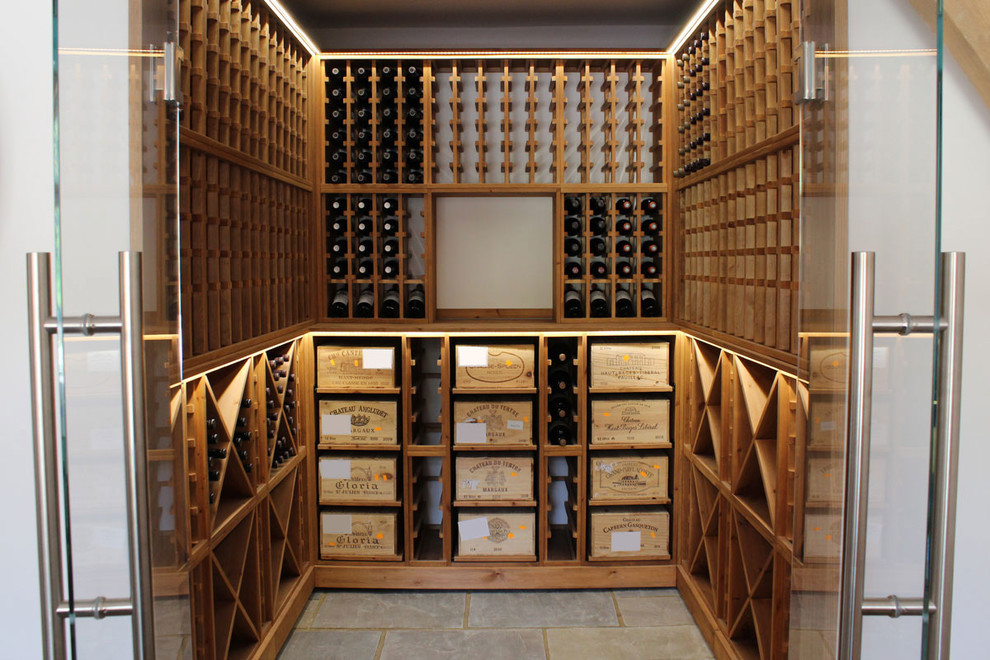 This is an example of a medium sized contemporary wine cellar in Sussex with ceramic flooring, storage racks and grey floors.