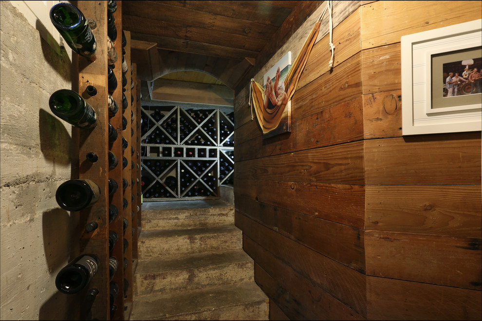 Wine cellar - concrete floor wine cellar idea in Portland with storage racks
