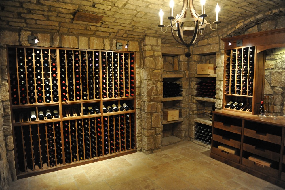 Idée de décoration pour une grande cave à vin chalet avec tomettes au sol et un présentoir.