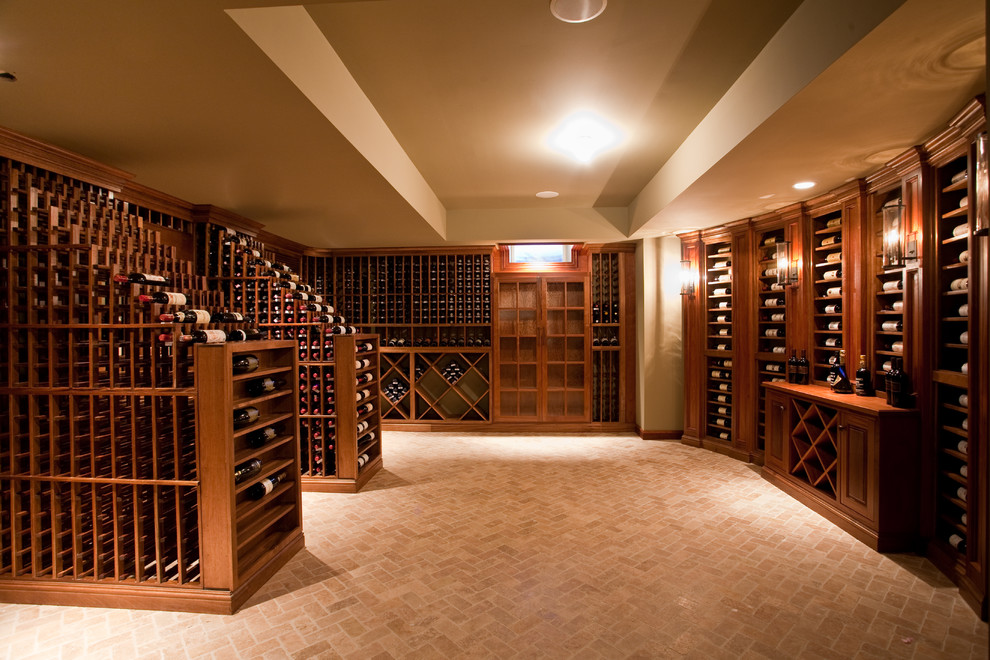 Huge elegant brick floor wine cellar photo in New York with display racks