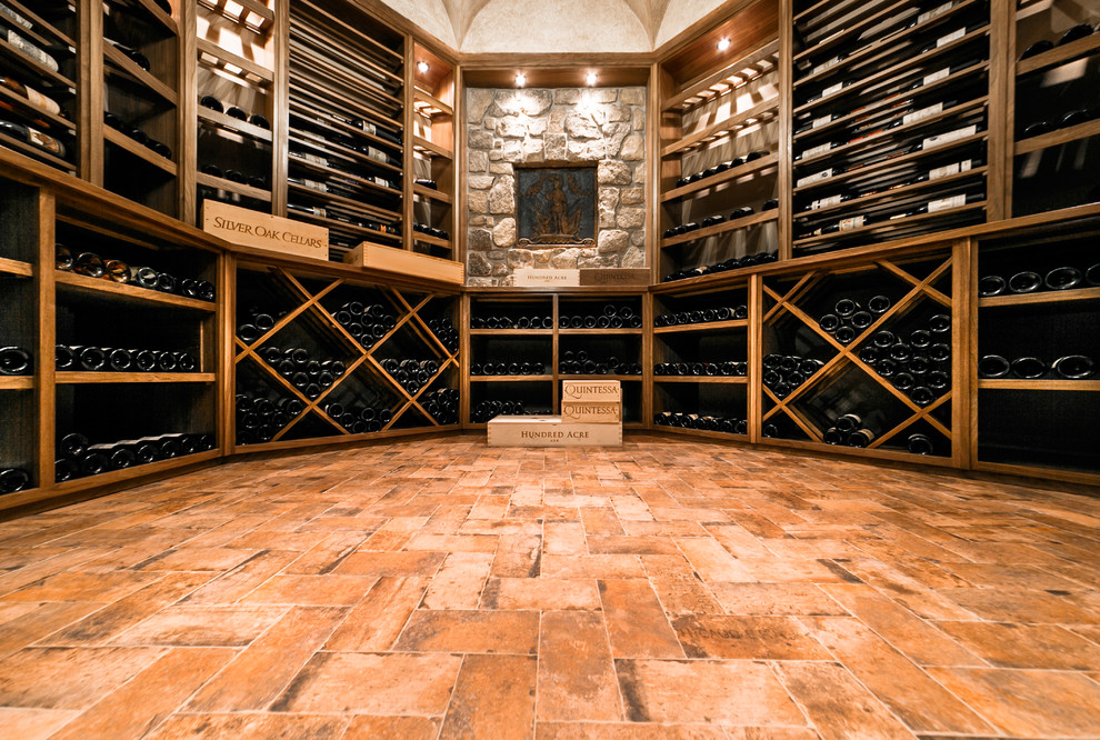 Foto på en stor vintage vinkällare, med tegelgolv, vinhyllor och orange golv