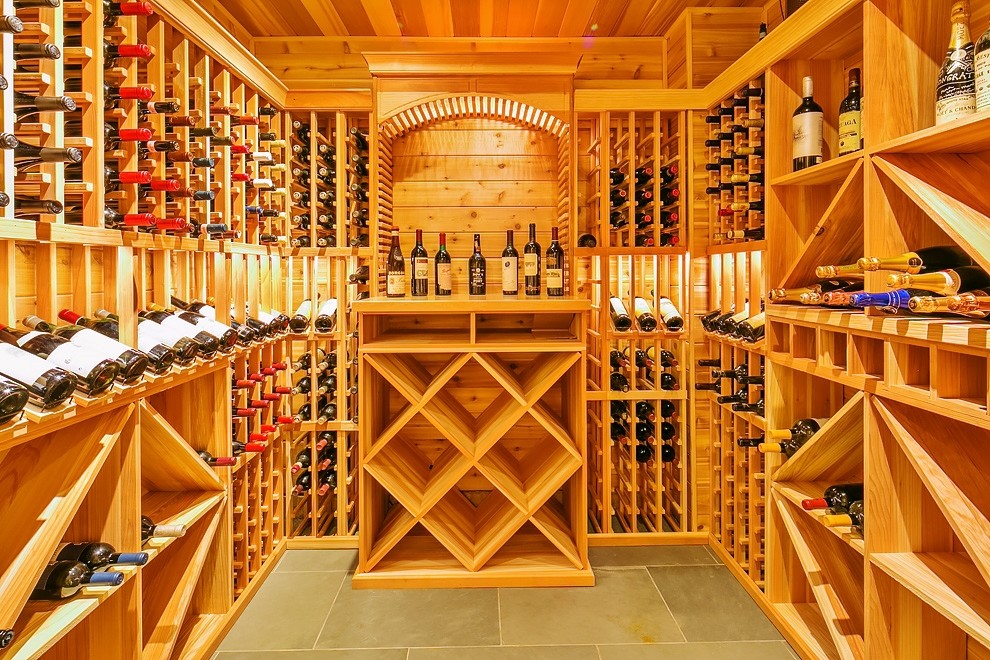 Idée de décoration pour une grande cave à vin craftsman avec un sol en carrelage de porcelaine et des casiers.