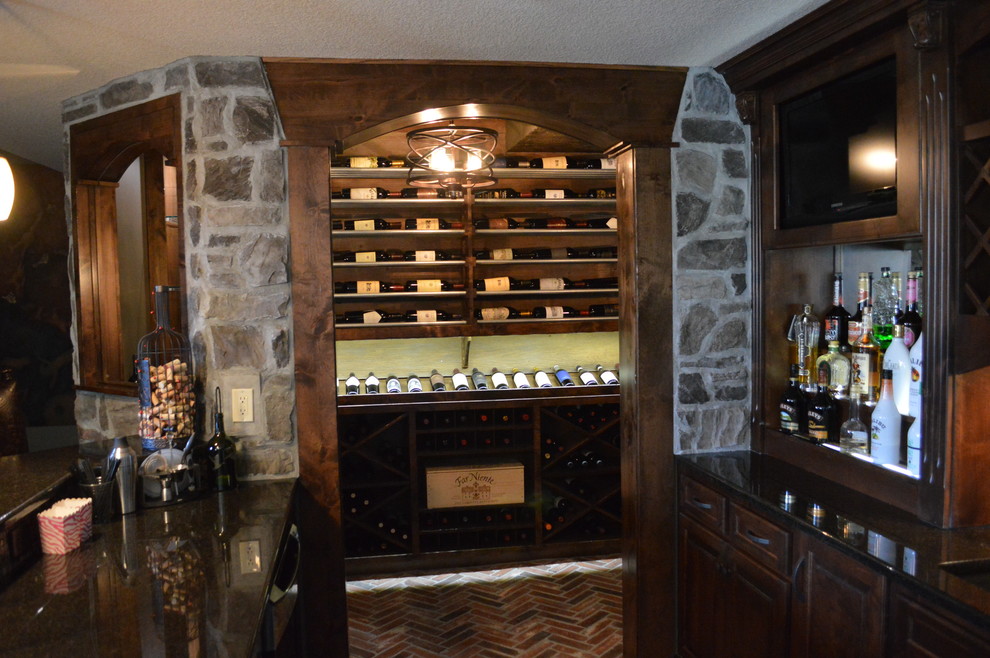 Cette image montre une petite cave à vin traditionnelle avec un sol en brique et des casiers.