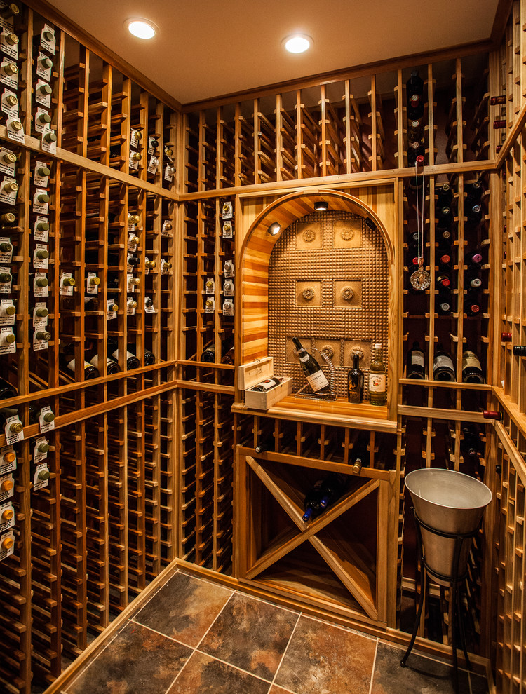 Idée de décoration pour une cave à vin design de taille moyenne avec un sol en travertin et des casiers.