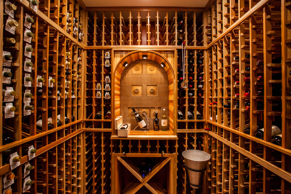 Cette image montre une cave à vin traditionnelle de taille moyenne avec des casiers et un sol en travertin.