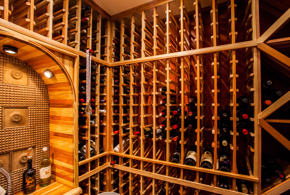 Idée de décoration pour une cave à vin design de taille moyenne avec un sol en travertin et des casiers.